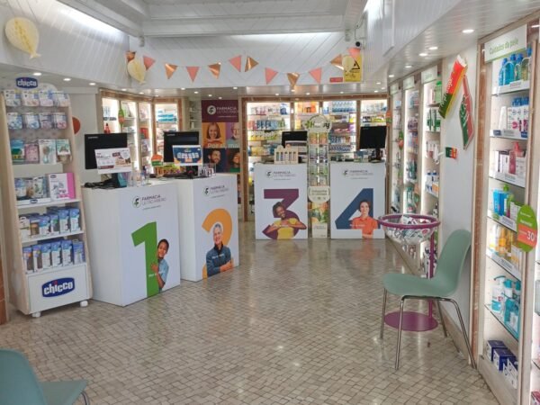 Interior amplo da Farmácia Leitão Ribeiro, com os lineares de produtos de saúde e a zona de atendimento.